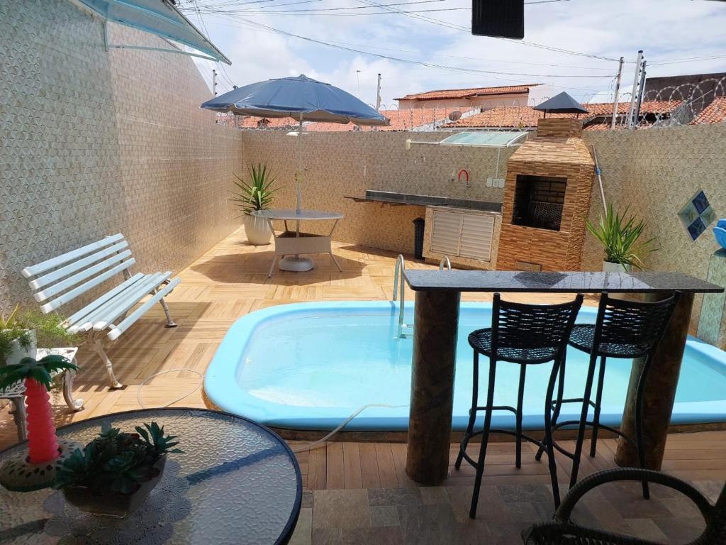 阿拉卡茹CASA próximo PRAIA para temporada的庭院设有热水浴池、桌子和椅子。
