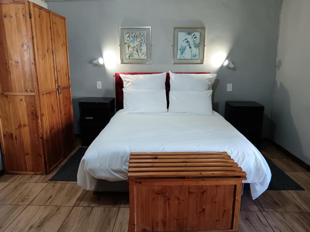 MachadodorpThe Grey's Inn的一间卧室配有一张大床和一个木制橱柜