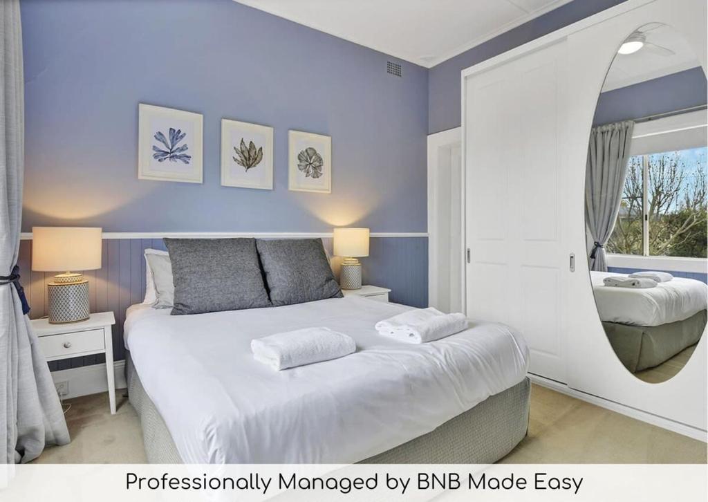 奥兰治Kinross Cottage Close to CBD Comfy & Convenient的一间卧室配有一张带蓝色墙壁的大床