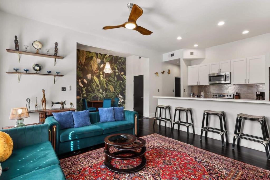 新奥尔良Stylish 2-Bedroom Apartment in Garden District的一间带蓝色沙发的客厅和一间厨房