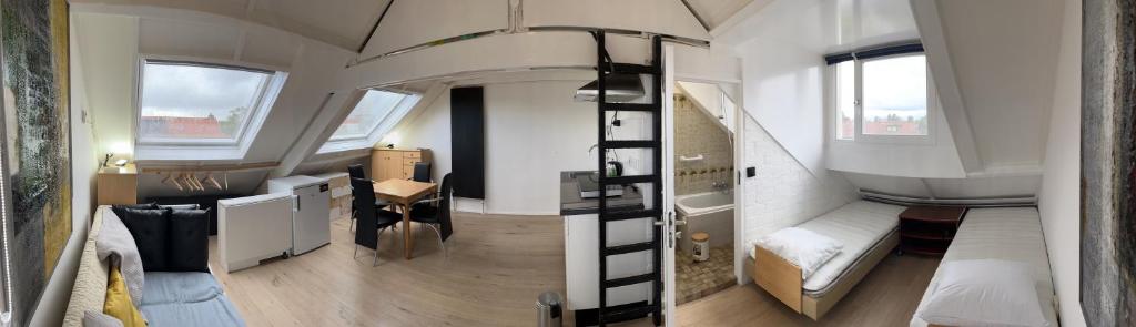 奈梅亨Studio met eigen badkamer en eigen keuken的一间设有双层床的小房间和一间带书桌的房间