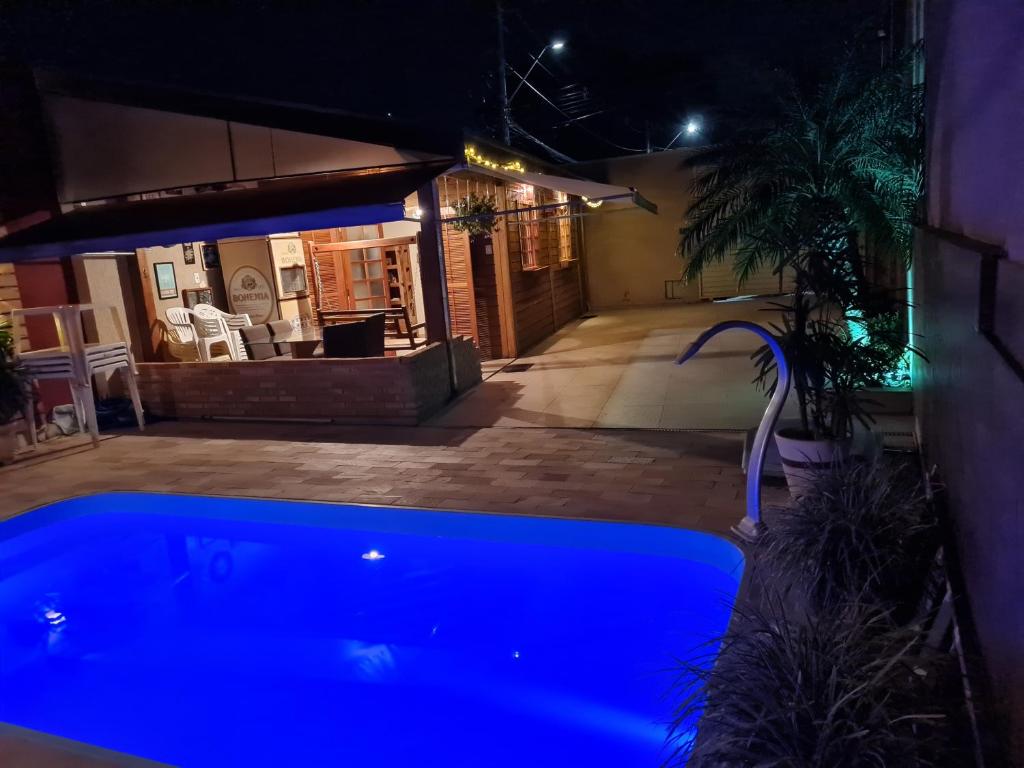 陶巴特Rancho da Malu的夜晚在院子里的一个蓝色游泳池