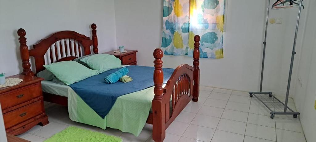 勒罗贝尔Villa Léïna的一间卧室配有一张带蓝色床单和蓝色枕头的木床。
