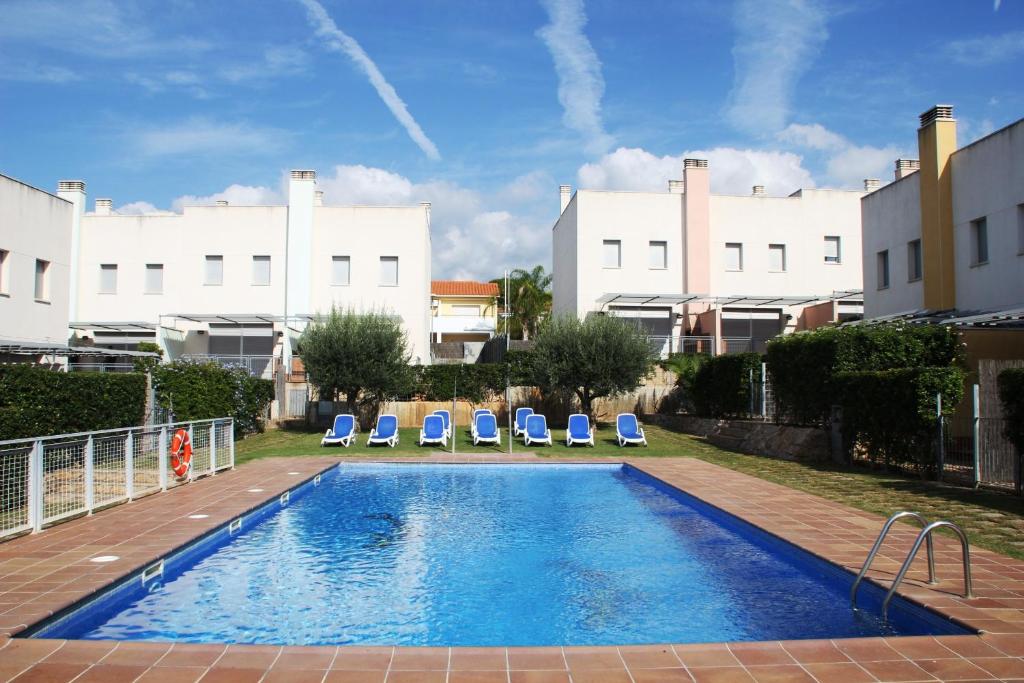 克雷克塞利霍图尔维亚奥古斯塔酒店公寓的一座带两把躺椅的游泳池以及一座建筑