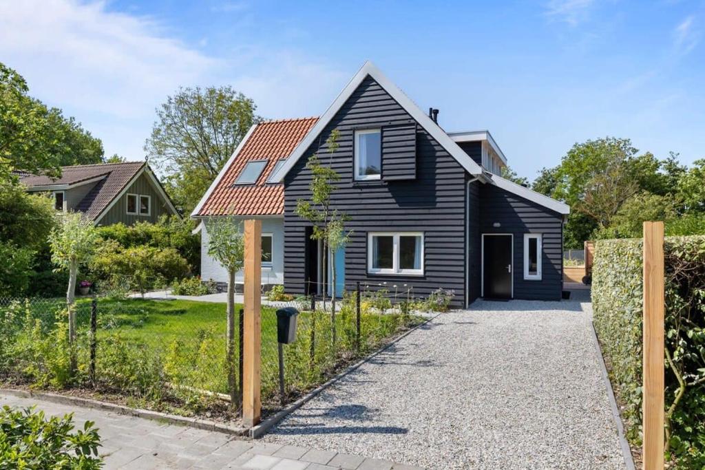 栋堡NEW Hello Zeeland - Vakantiehuis Jhr De Casembrootplein 19的一间红色屋顶的黑色房子