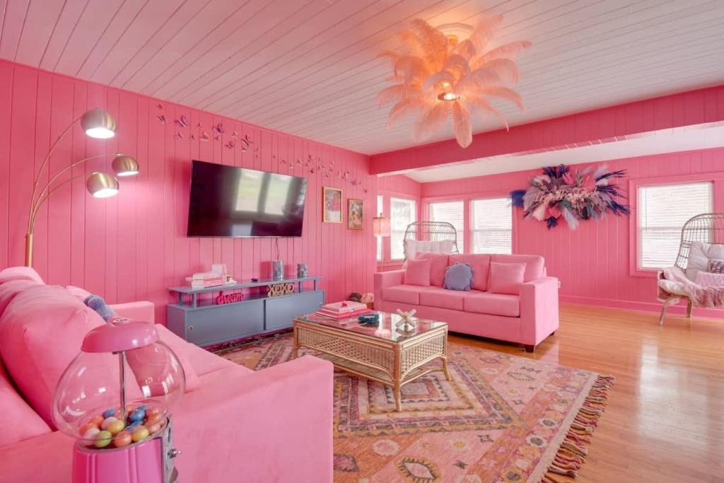 默特尔比奇Inn the Pink One-in-a-Million Vacation Home的粉红色的客厅配有粉色家具和电视