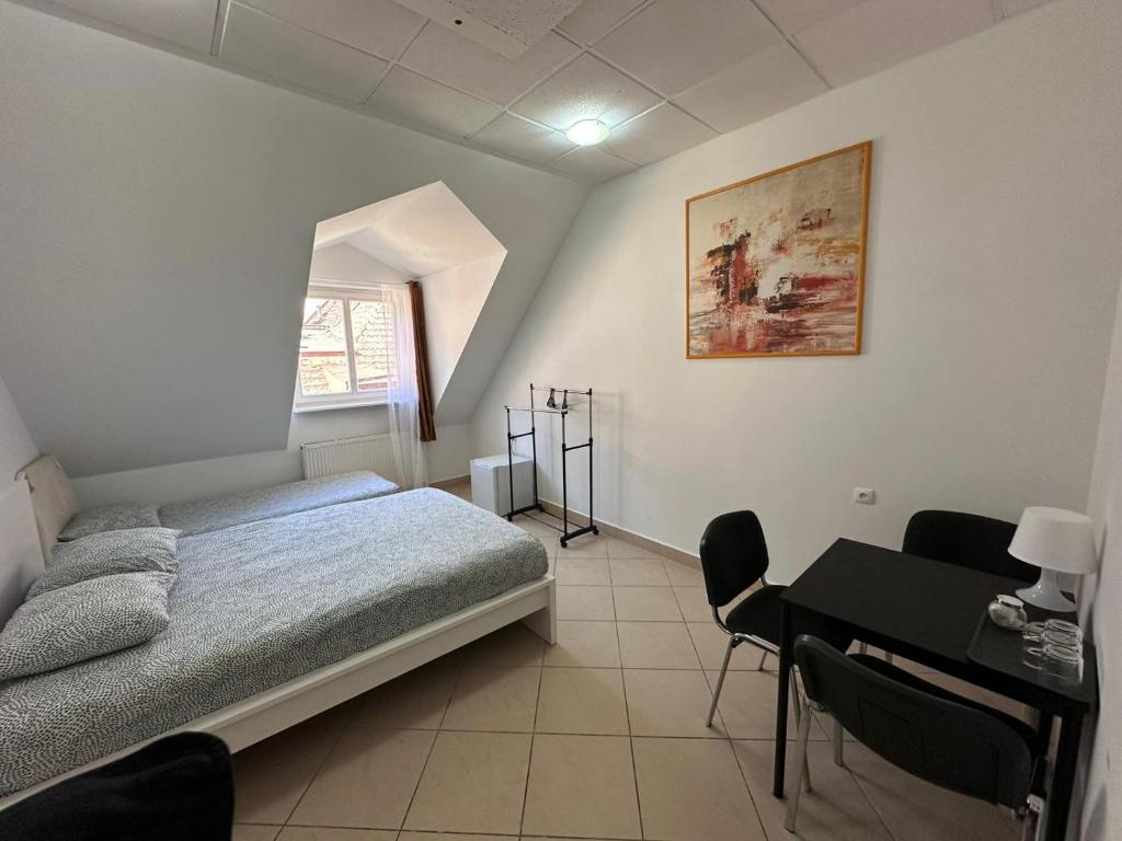 波兹南Apartamenty Gołębia-Economic的一间卧室配有一张床和一张桌子及椅子