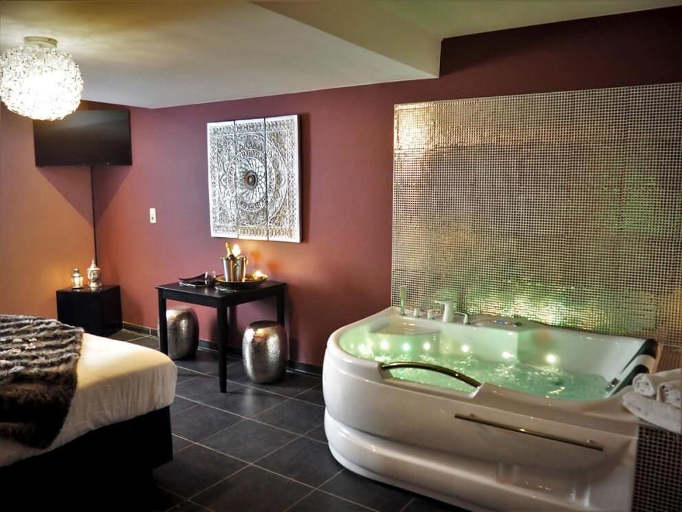 沙勒罗瓦Symbiose hotel的带浴缸和床的大型浴室