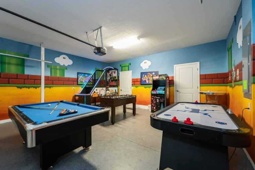 基西米Charming 9BR Villa w Theme & Game Rooms by Disney的一间设有两张台球桌的房间和一间设有游戏的游戏室