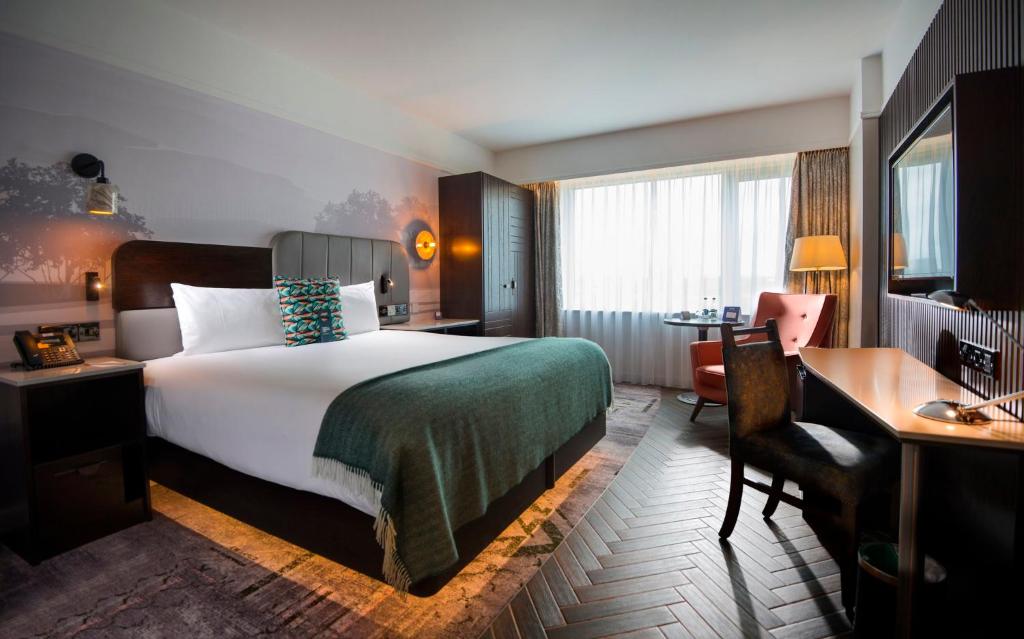 布兰察斯镇都柏林皇冠假日酒店布兰查的酒店客房设有一张大床、一张书桌和一张书桌。