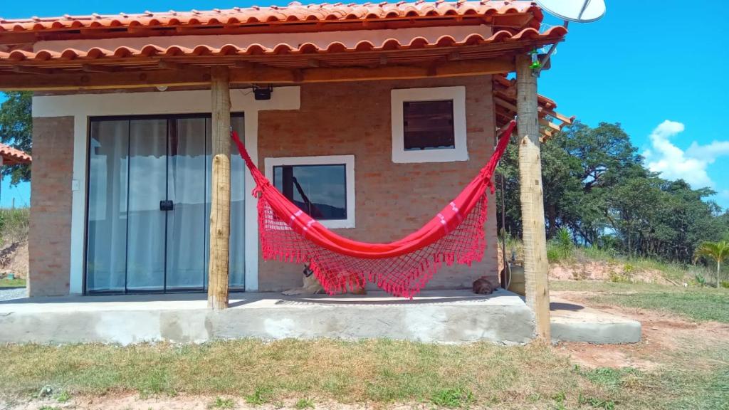 圣托梅-达斯莱特拉斯Chales Paraíso STL的前面有红色吊床的房子