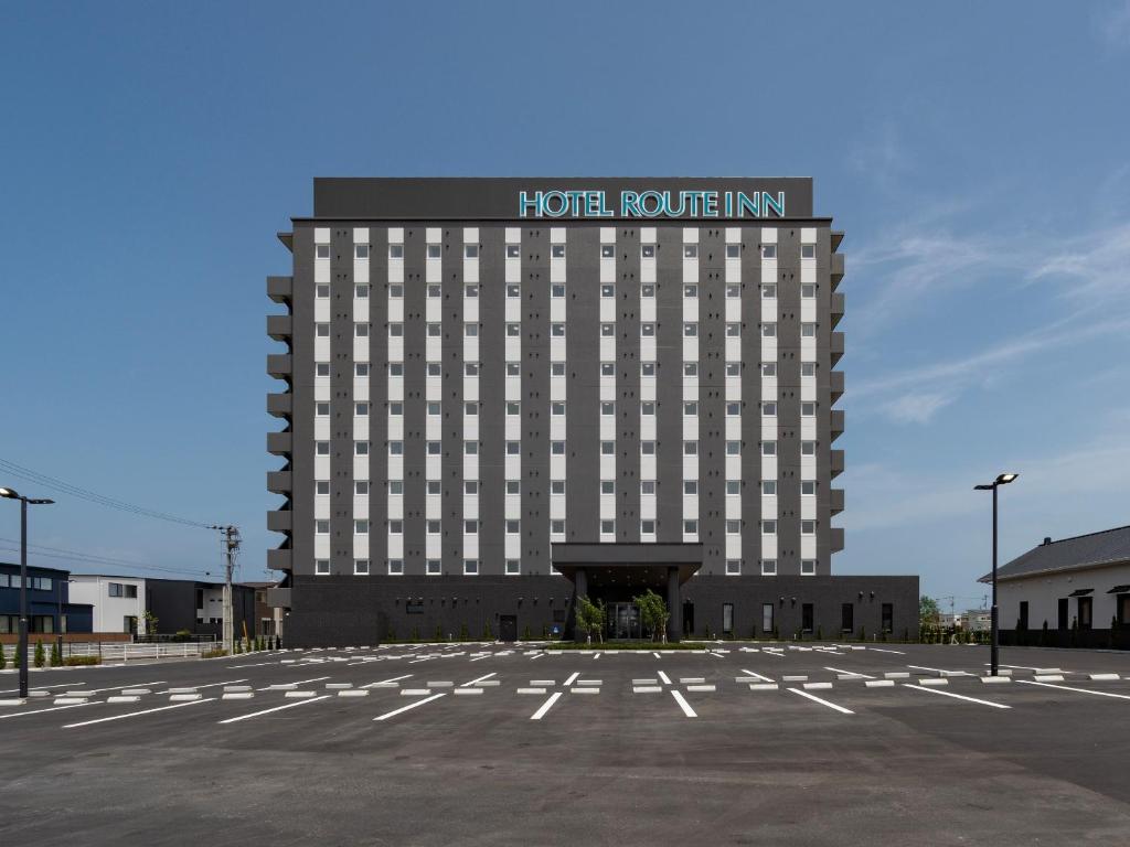 松茂町Hotel Route Inn Tokushima Airport -Matsushige Smartinter-的酒店大楼前面设有停车场