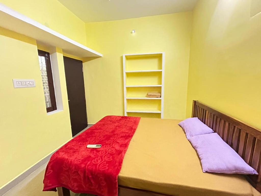 蓬蒂切里SELVAS BUDGET STAY的一间卧室配有一张床铺,床上铺有红色毯子