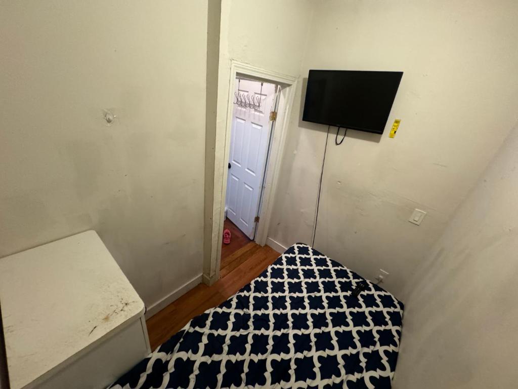 波士顿Private Room Near to Downtown Boston的小房间设有一张床和墙上的电视