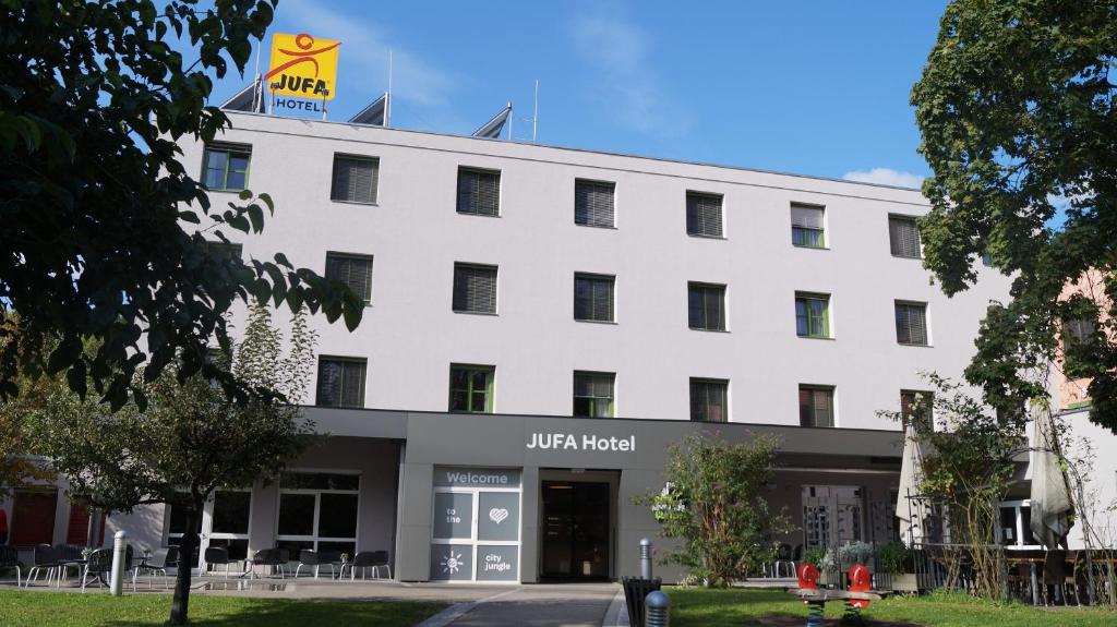 格拉茨JUFA Hotel Graz City的白色的建筑,上面有标志