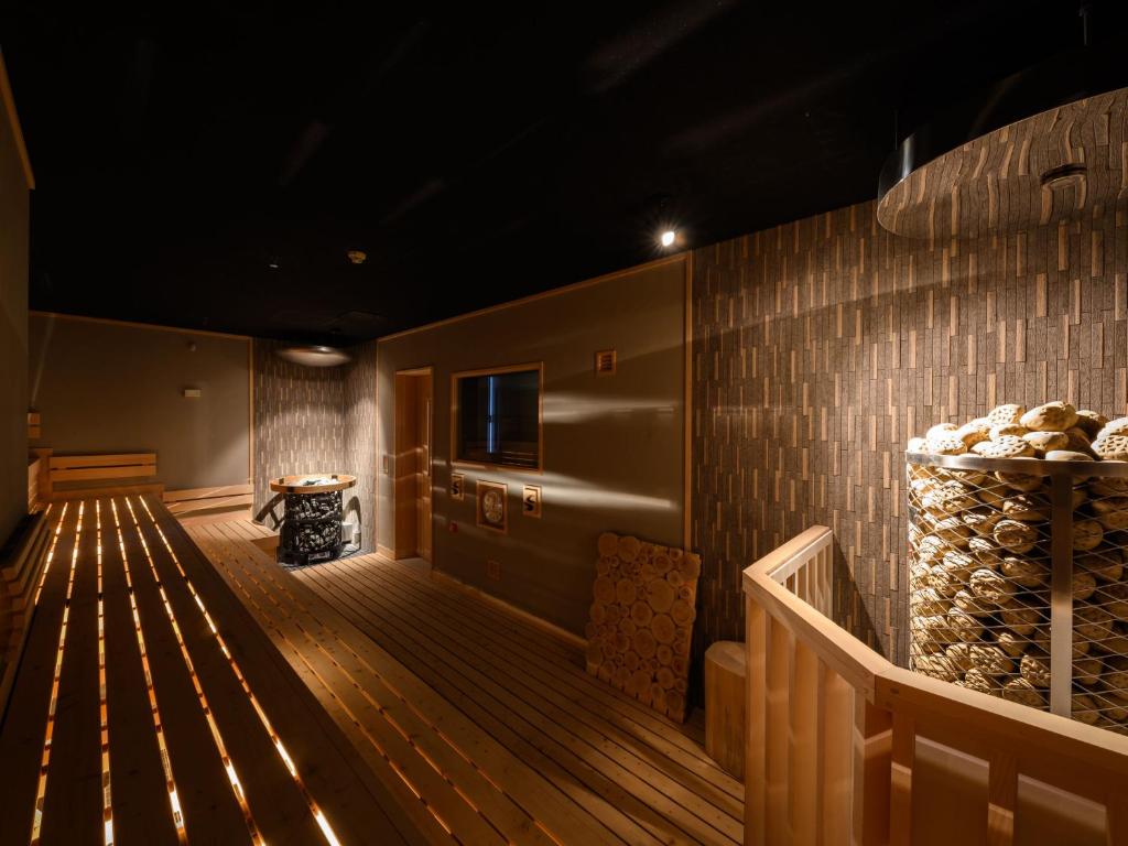 札幌The Centurion Sauna Rest & Stay Sapporo Male Only的客房铺有木地板,设有木墙。