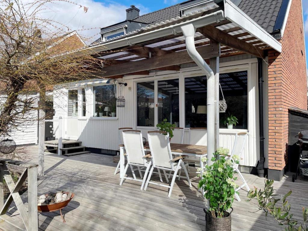 斯德哥尔摩Holiday home SPÅNGA的木制甲板上配有白色椅子的庭院