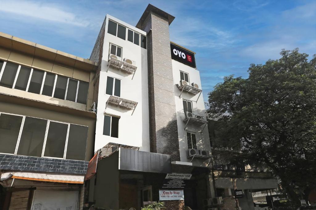 新德里Super OYO Hotel Mannat Near Lotus Temple的白色的建筑,上面有 ⁇ 首标志