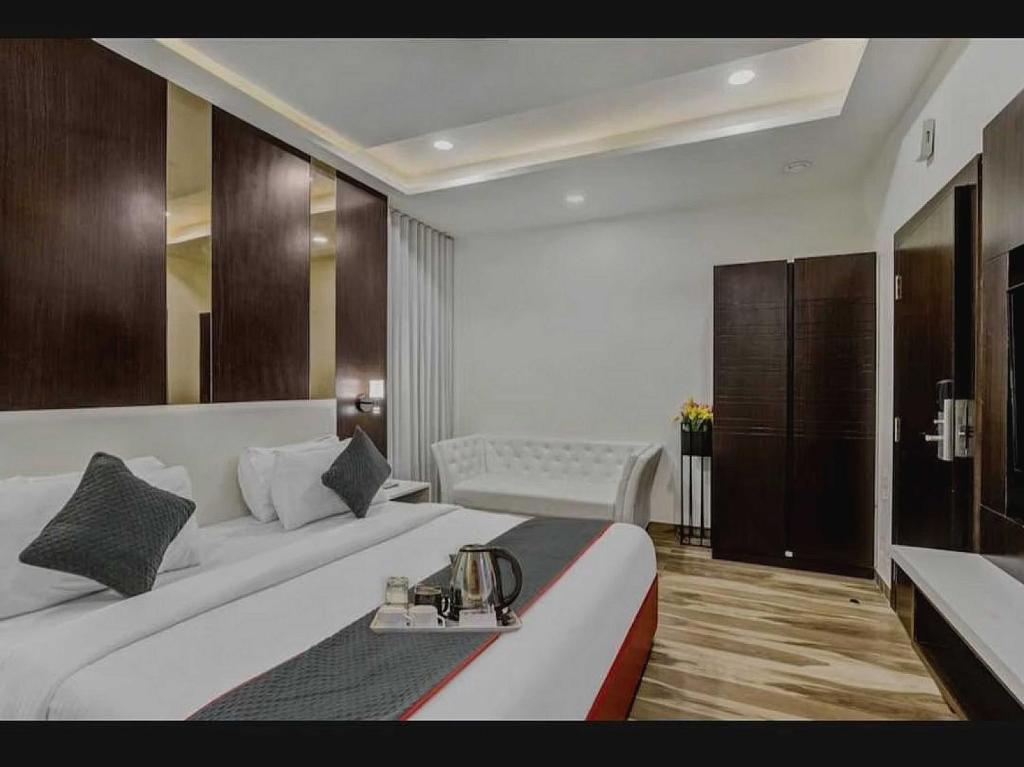 新德里Hotel Raas Near M2k Cinemas Rohini的酒店客房设有一张大床和一张桌子。