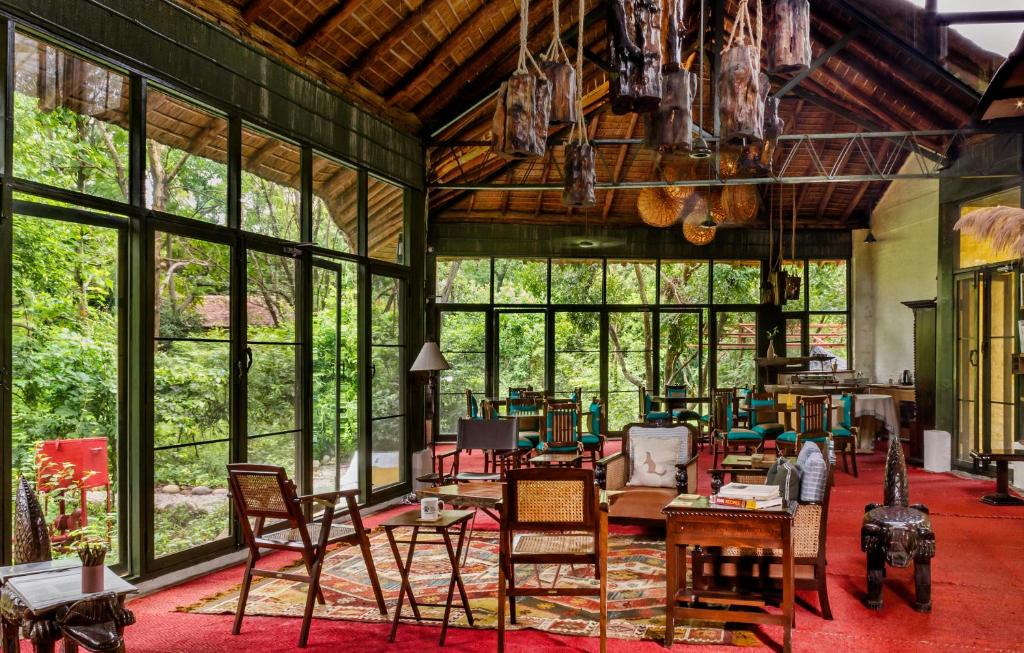 兰纳加Jim's Jungle Retreat的大型客房设有桌椅和窗户。