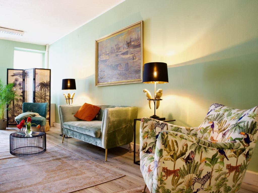 汉堡Apartmenthaus Hamburg Les Jardins的客厅配有两把椅子和一张沙发
