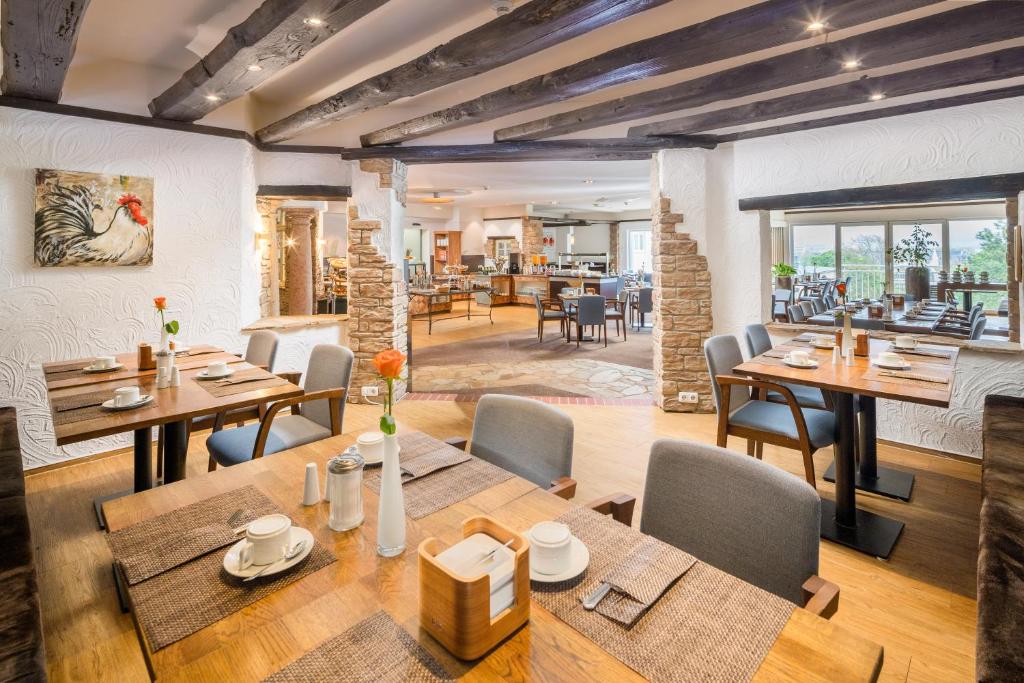 美因茨美因茨最佳西方酒店的用餐室配有木桌和椅子