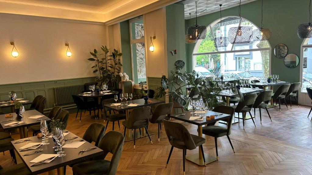 瓦尔莱班Logis Hôtel Restaurant Grand Hôtel de Lyon的一间在房间内配有桌椅的餐厅