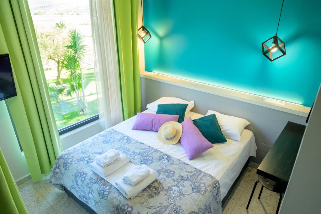 利吉亚Bikini Apartments的带毛巾和窗户的床的客房