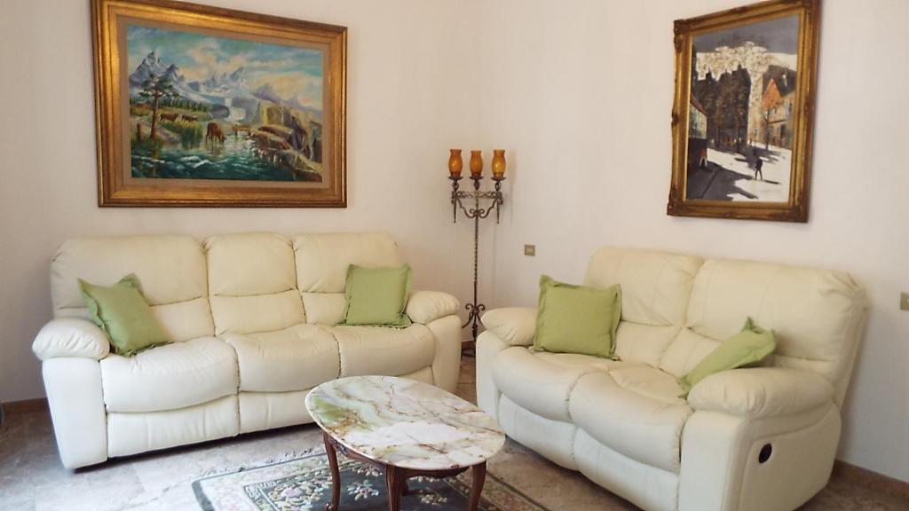 蒙特普齐亚诺萨提尼克公寓的客厅配有2张白色沙发和1张桌子