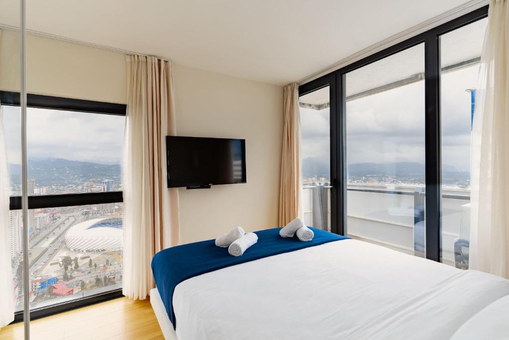 巴统Elegance Sea View Aparthotel In Orbi City Batumi的一间卧室设有一张床和一个大窗户