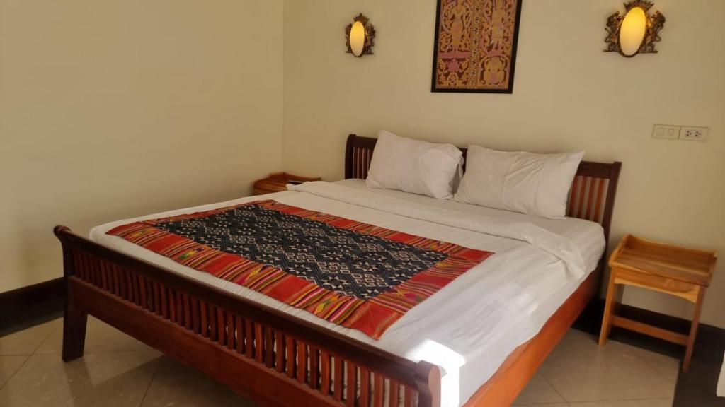 琅勃拉邦Phasouk Viengmai Villa的一张床上的毯子,放在房间里