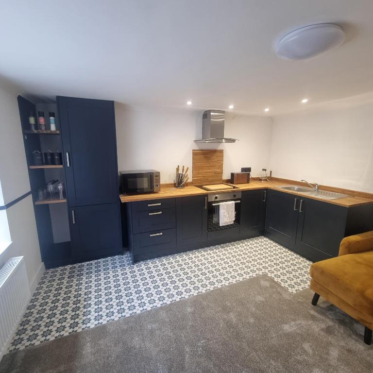 普里茅斯Quite central flat的厨房配有蓝色橱柜和水槽