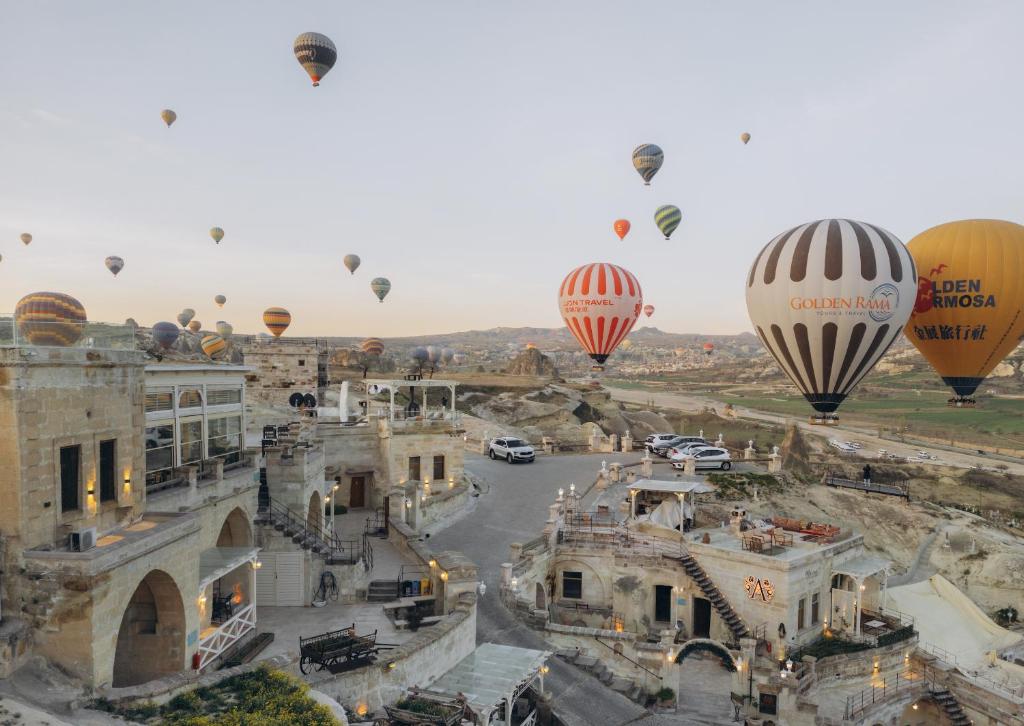格雷梅Azure Cave Suites - Cappadocia的一群热气球飞越城市