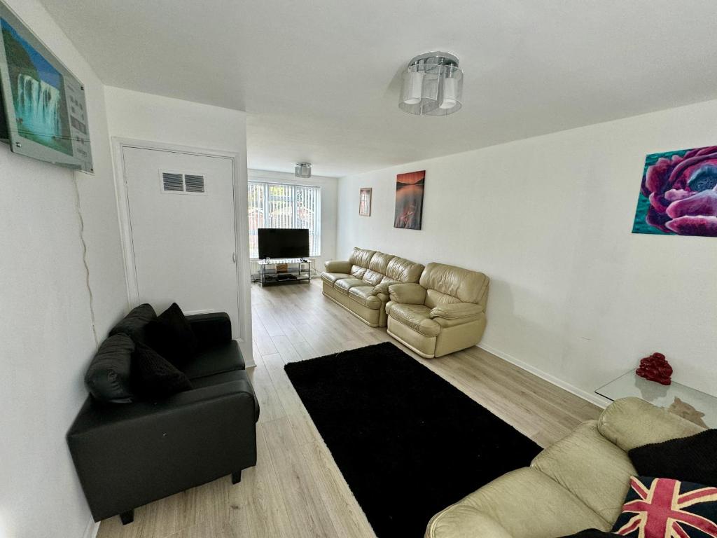 特威克纳姆Cozy Home的客厅配有两张沙发和一台电视