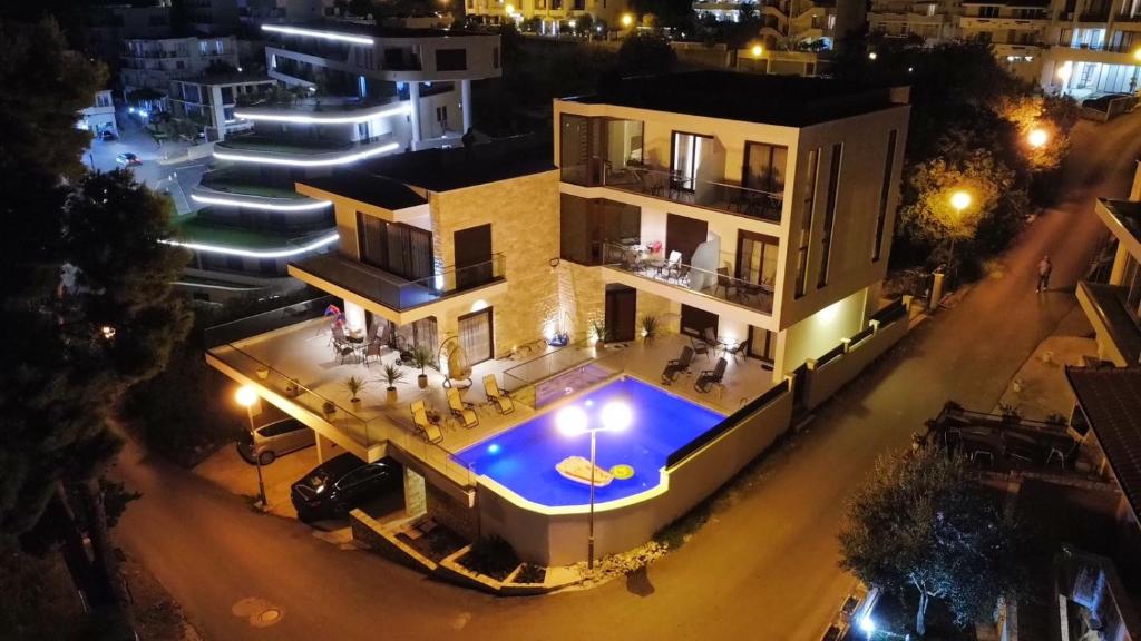 乌尔齐尼Arté Apartments的享有房子空中景色,晚上设有游泳池