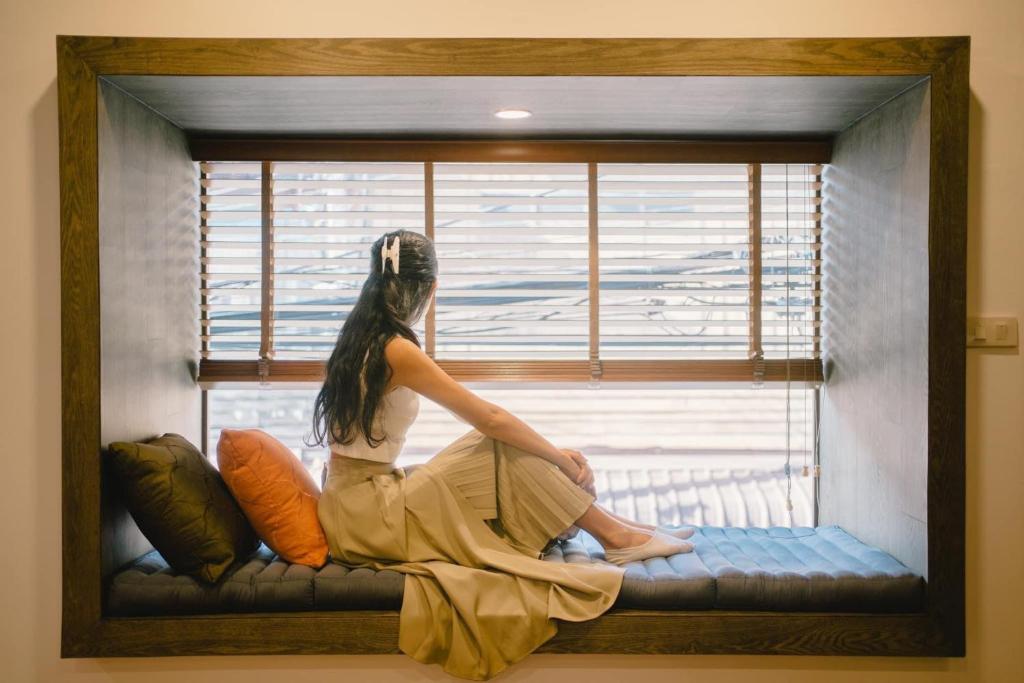 清刊The Folkster House Chiangkhan的坐在窗边望着窗外的女人