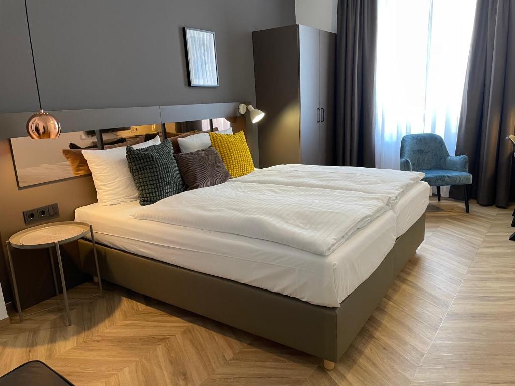 奥斯纳布吕克多梦酒店的卧室内的一张大床,配有蓝色椅子