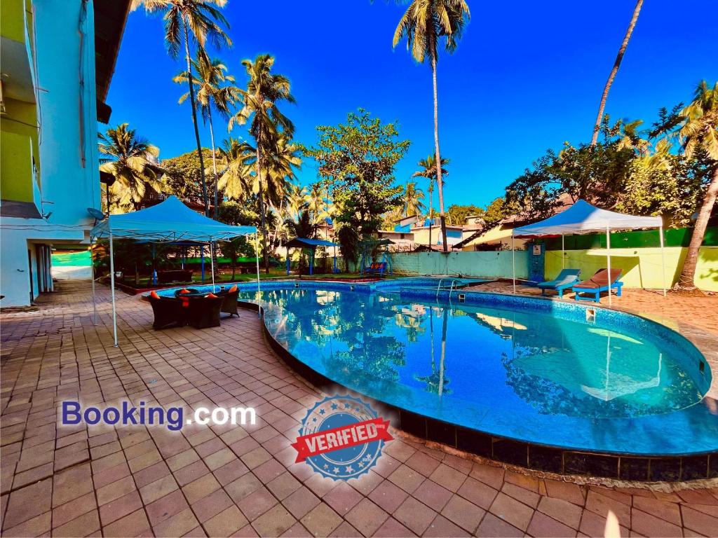 GoaHotel in GOA With Swimming Pool ,Managed By The Four Season - Close to Baga Beach的棕榈树度假村的游泳池