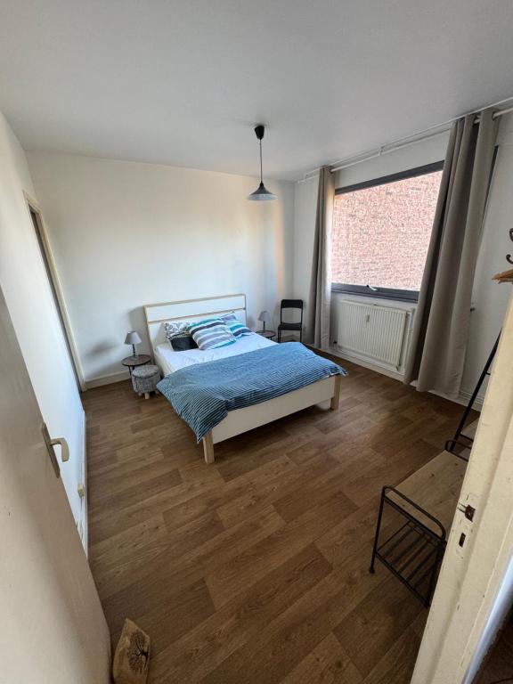 里尔Rijsel Vlamse的一间卧室设有一张床和一个大窗户
