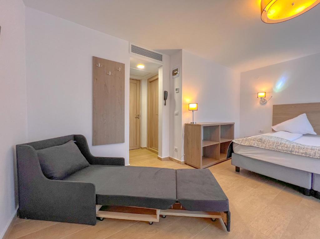 百乐·奥拉内斯蒂Aurora Rooms - 290m from Aqua Park的一间卧室配有一张床和一个沙发