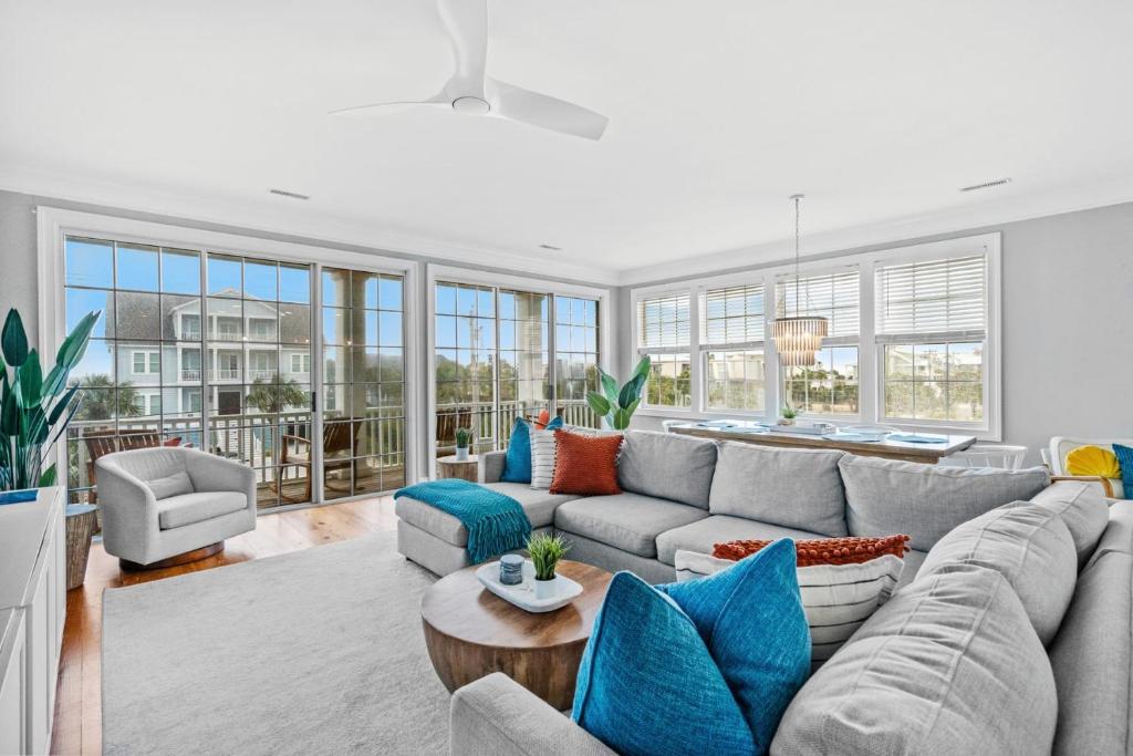 默特尔比奇Luxury Beach House Ocean AND Inlet Views的客厅配有灰色的沙发和蓝色的枕头。