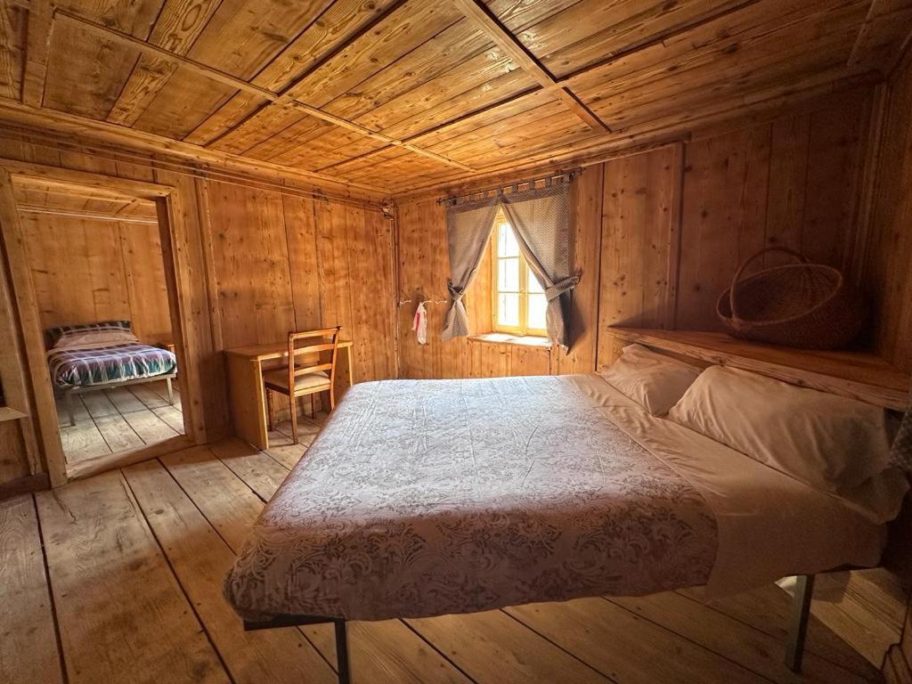 马代西莫Rifugio Teggiate的小木屋内一间卧室,配有一张床