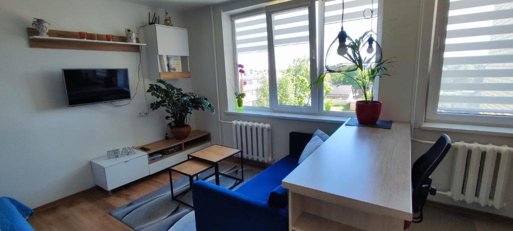 帕内韦日斯R&J Apartment II的客厅配有桌子和蓝色椅子