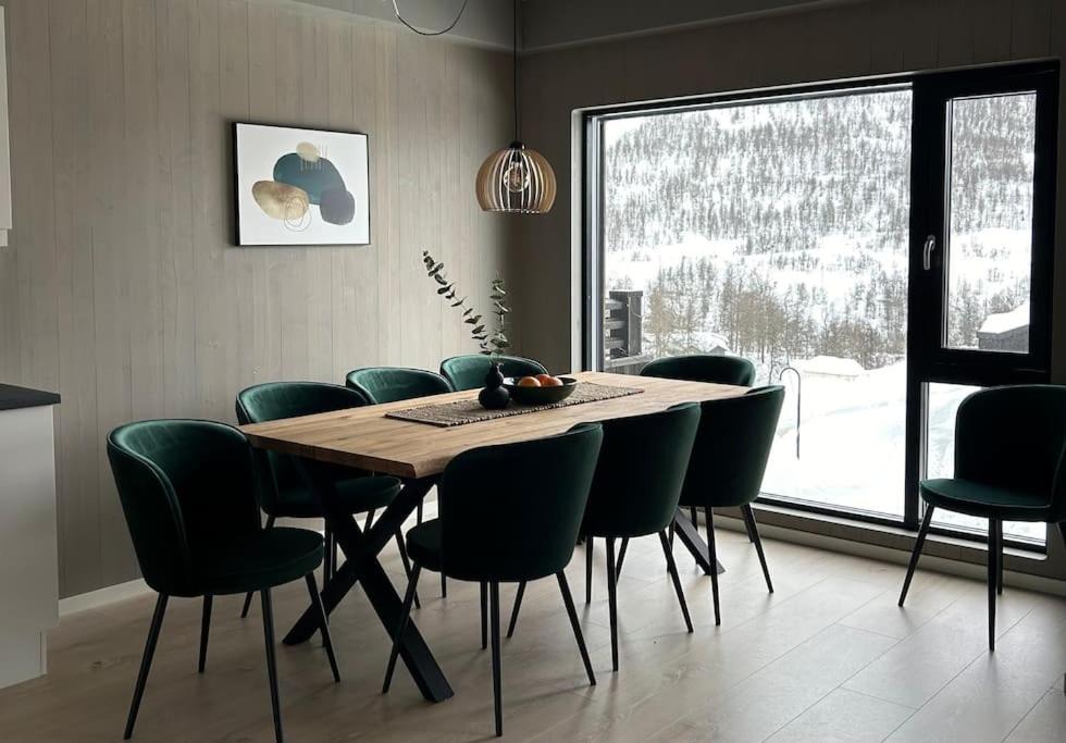 VossestrandOvernatting på Helgatun Fjellpensjonat AS i Myrkdalen的一间带木桌和绿色椅子的用餐室