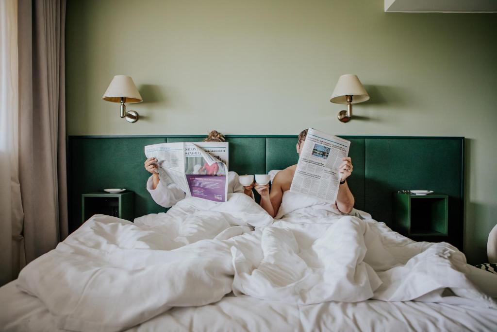 萨洛费加拉酒店的躺在床上看报纸的人