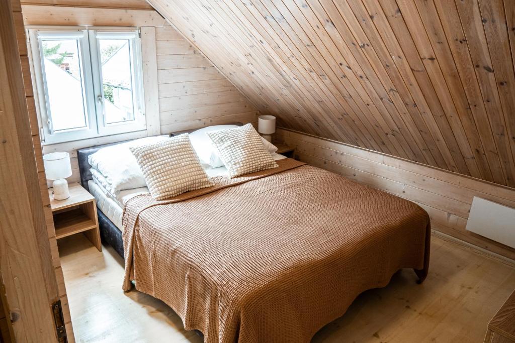 尤斯托尼莫斯基Collins Beach的木制客房内的一间卧室,配有一张床