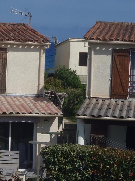 波吉奥· 梅扎纳Villa frati的两栋房子,有红色屋顶,有海洋背景