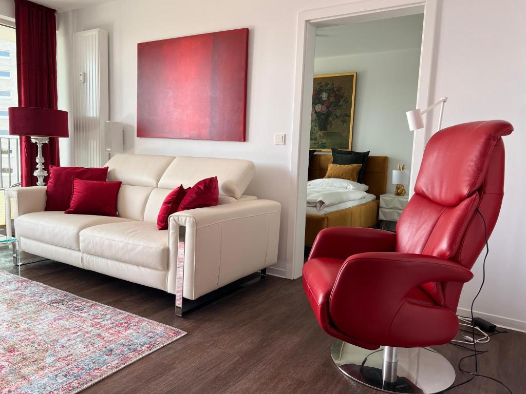 罗斯托克Exklusives Business & Living Apartment的客厅配有白色沙发和红色椅子