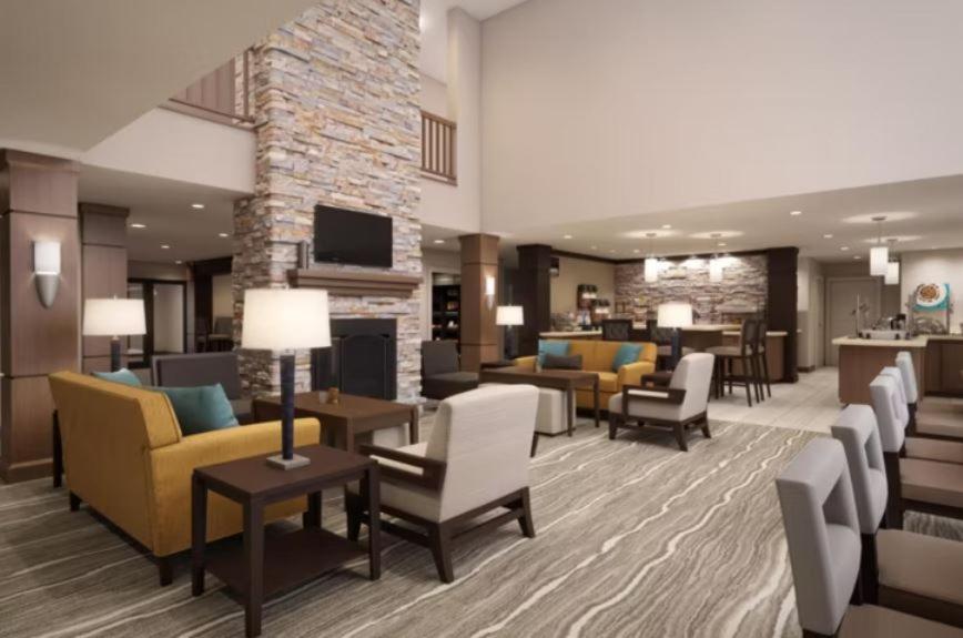 德斯坦Staybridge Suites Miramar Beach - Sandestin Area, an IHG Hotel的酒店大堂设有沙发、椅子和壁炉