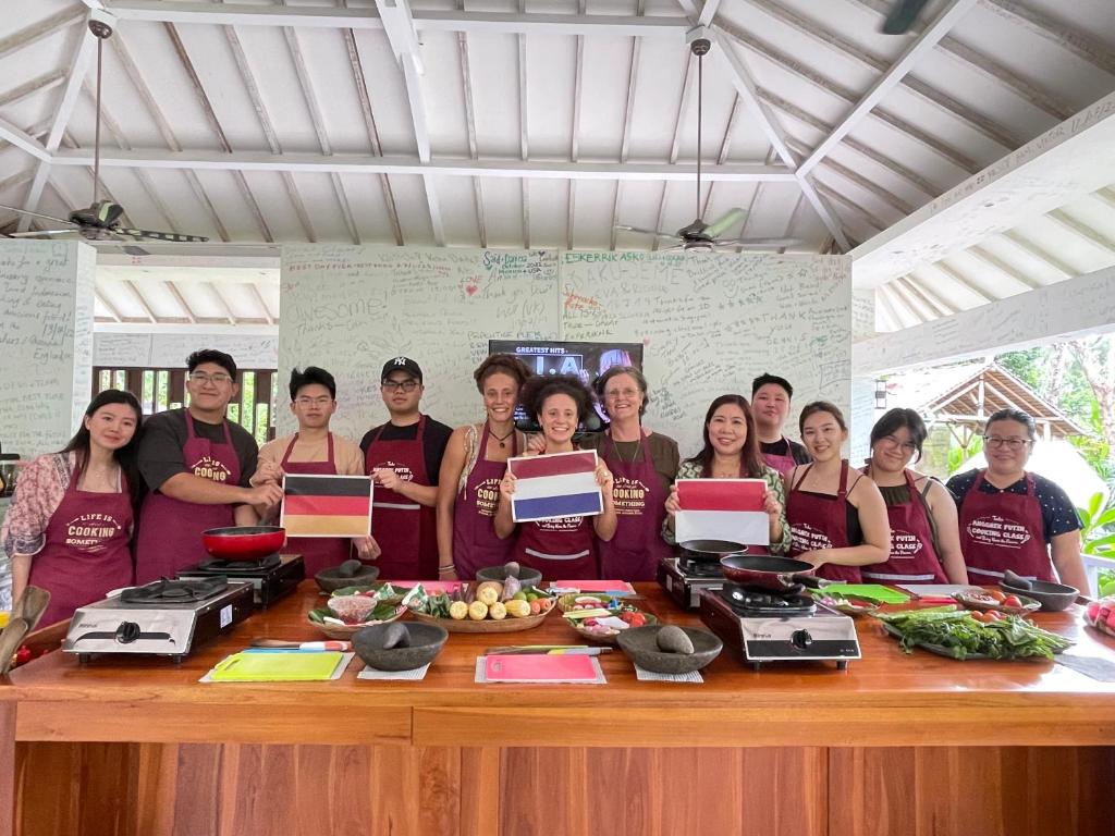 圣吉吉Anggrek Putih Homestay & Cooking Class的一群人站在桌子旁吃着食物